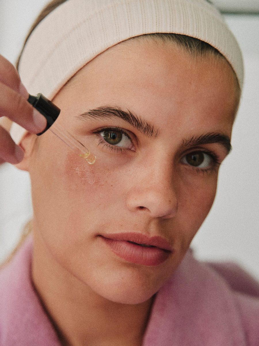 A serum dropper against the cheek